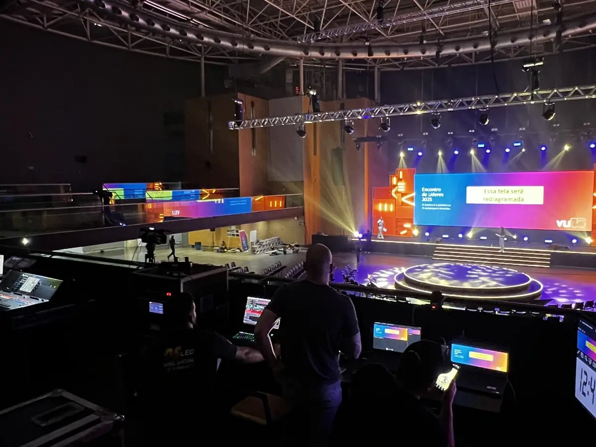 Régie de transmissão ao vivo da DHL Produções diante do palco de um grande evento empresarial